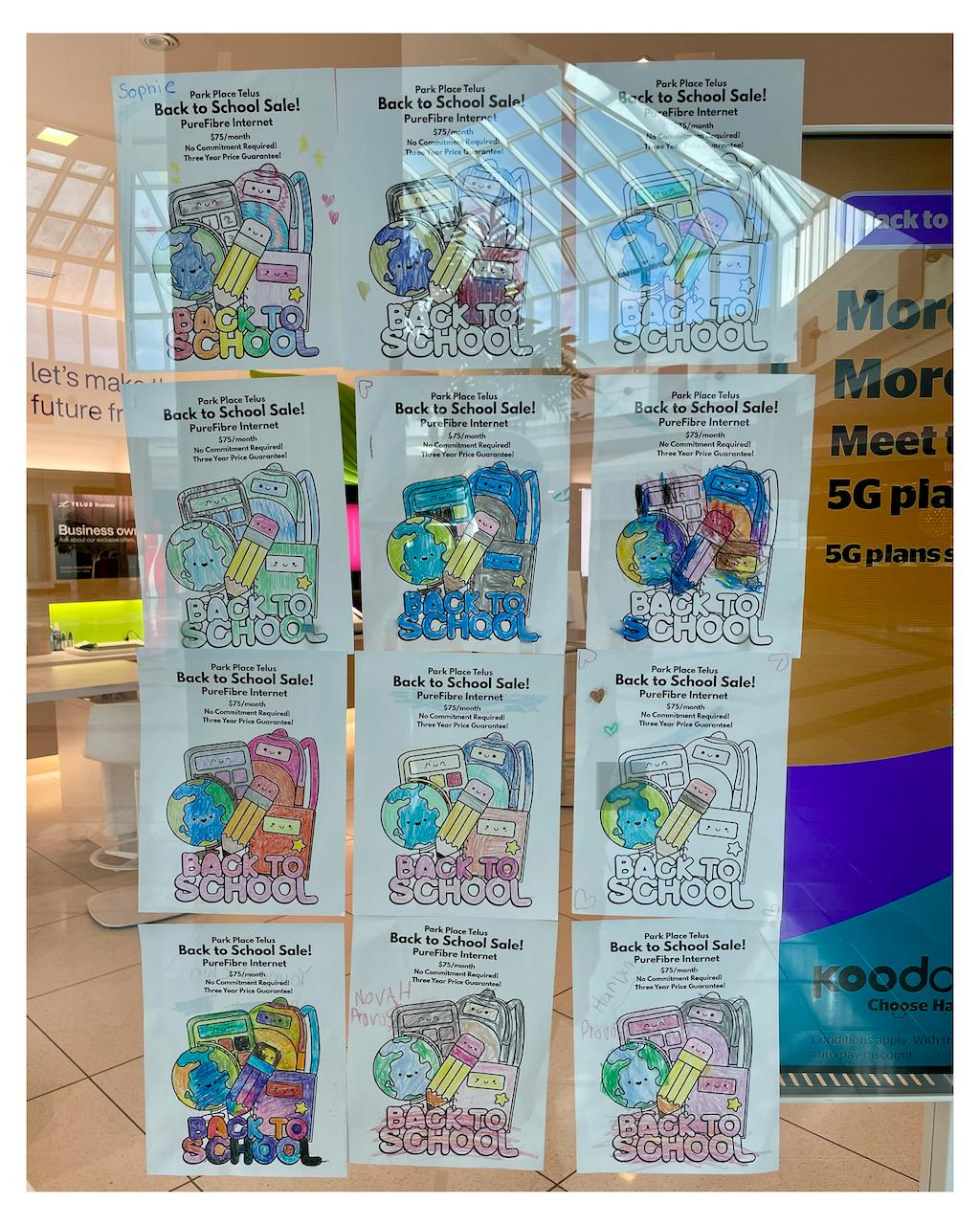 Multiple flyers featuring children’s drawings advertising a "Back to School Sale" with 'PureFibre Internet' offers are displayed on a glass window. The flyers are colorful and include images of school-related items like books and pencils. Reflected in the window is the interior of a mall, showing architectural details of the ceiling and other stores in the background. Some promotional text for mobile phone plans is also visible on the glass.